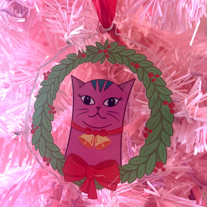 Lilac cat ornament with a wreath on a pink tinsel background