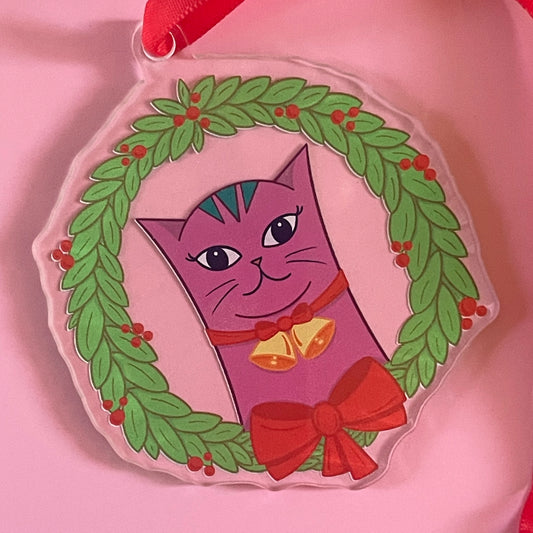 Christmas ornament with a lilac cat in a wreath on a pink background